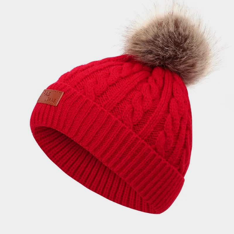 H00077 Gedraaide kindermuts met leren label en nep-haarbal